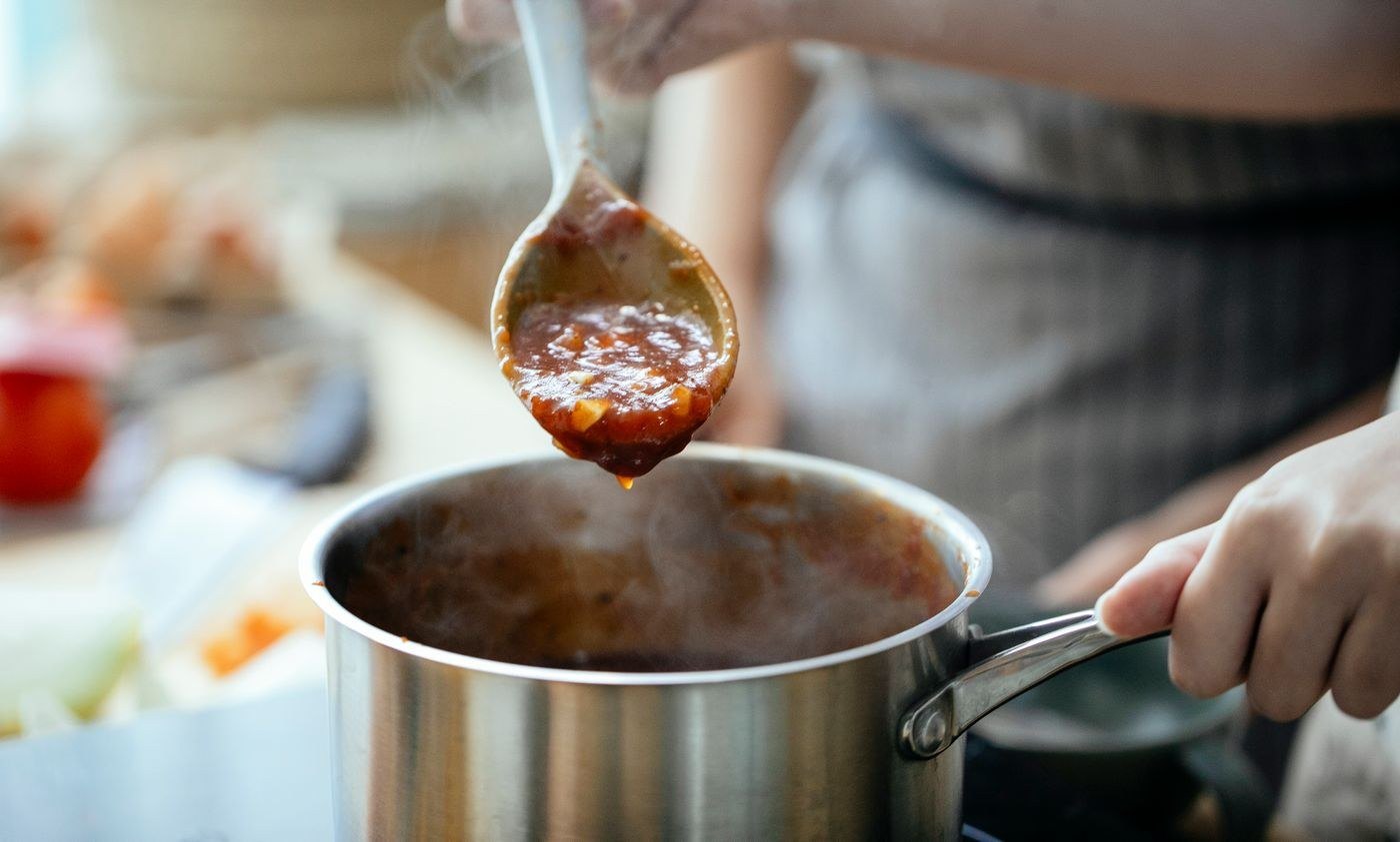 Stirring a cream sauce in a saucepan on the stove