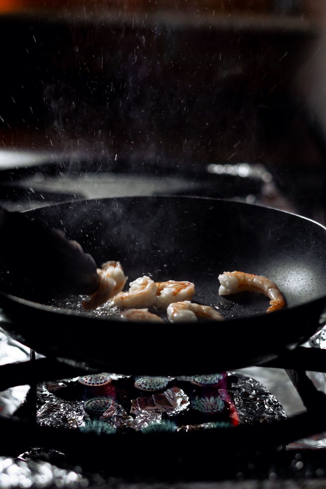 Shrimp cooking in a sizzling skillet